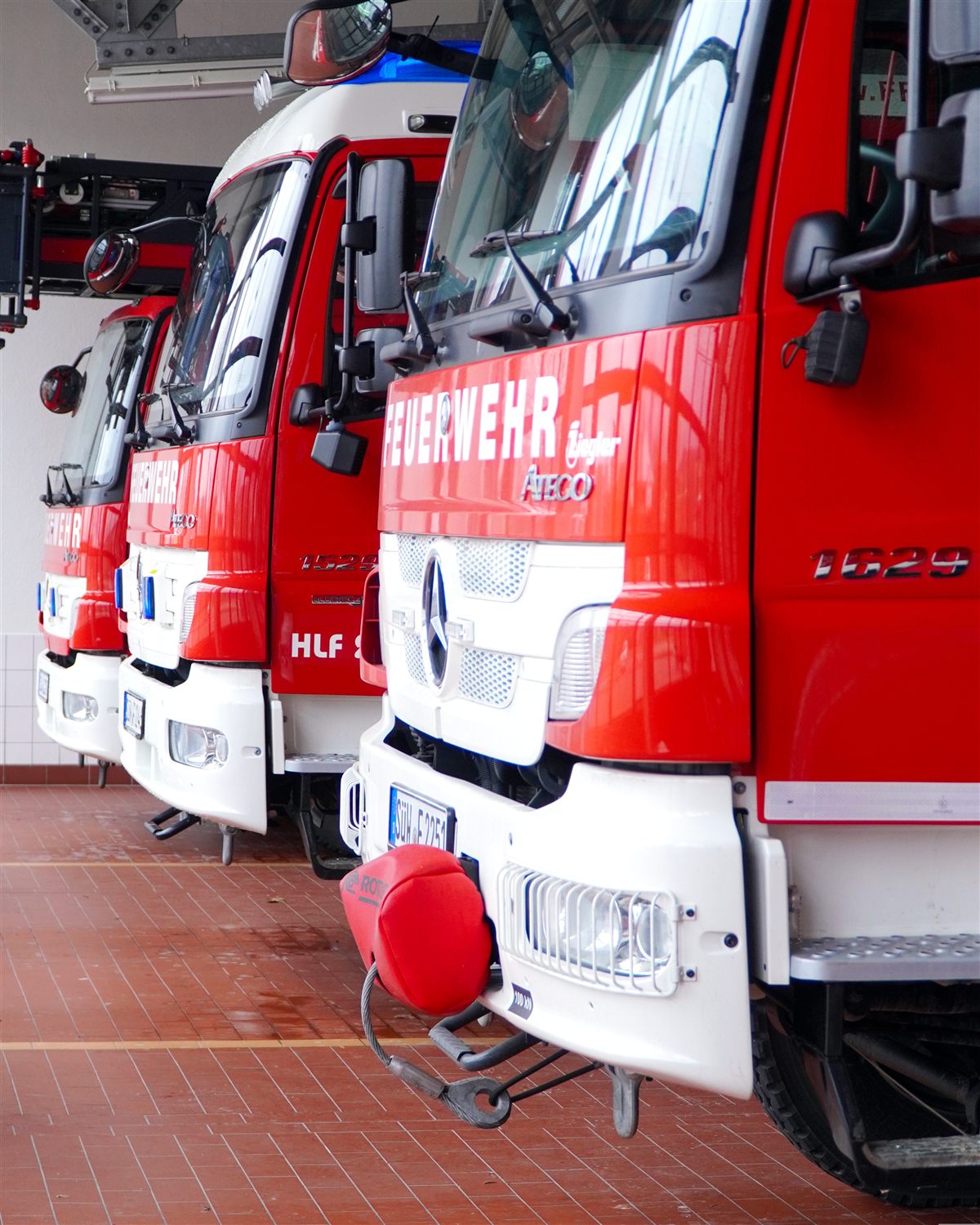 Einsatzfahrzeuge einer Feuerwehr-Fahrzeughalle (Symbolbild)